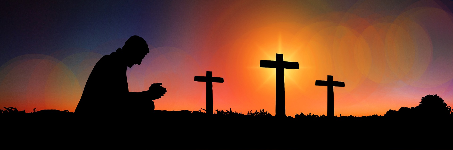 Person kneeling before 3 crosses at sunset